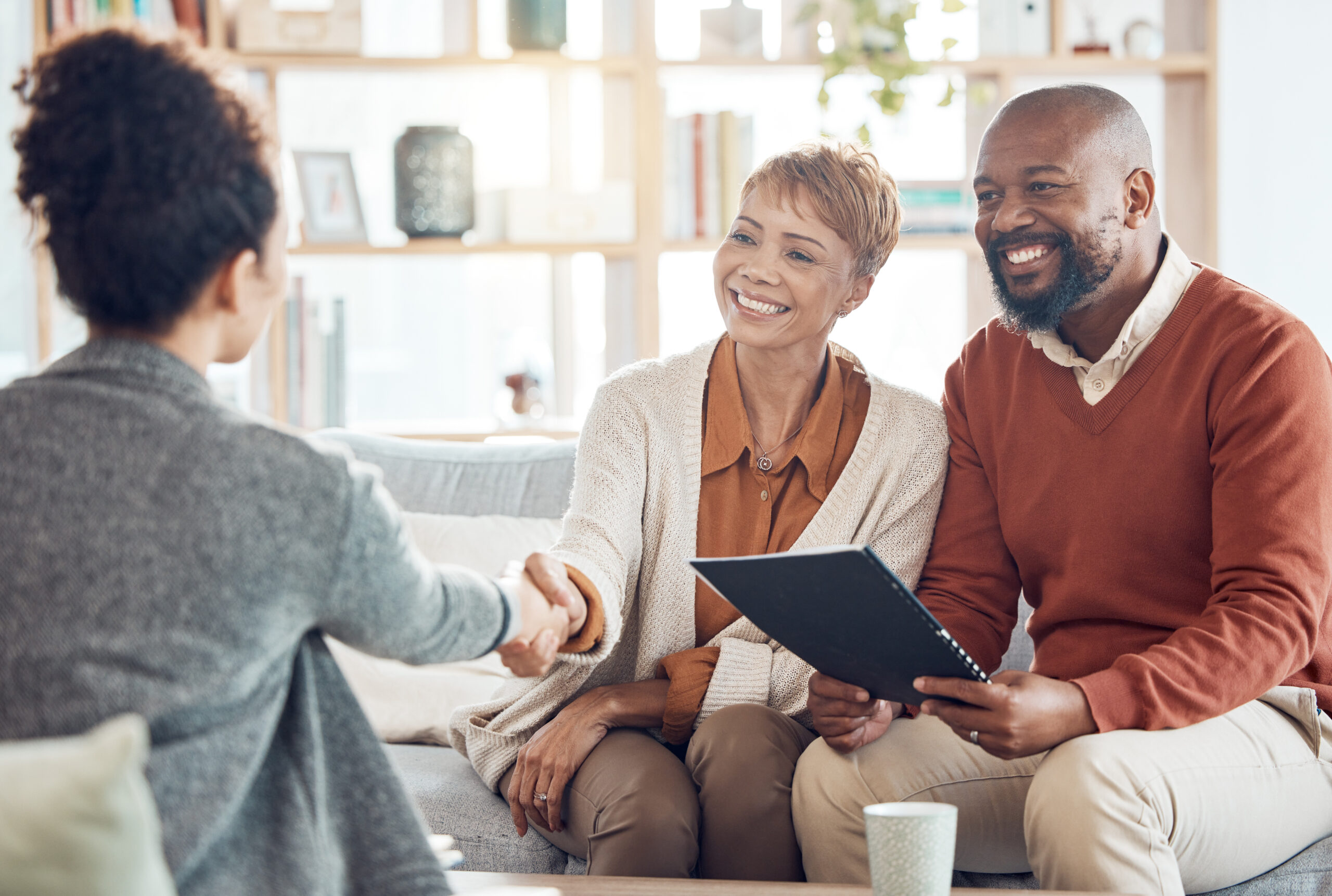 Couple shaking hands with advisor after estate tax planning meeting